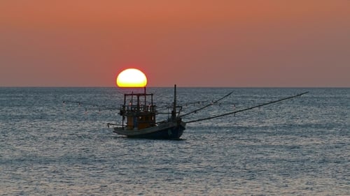 Fishing Boat in the Sea Against Setting Sun