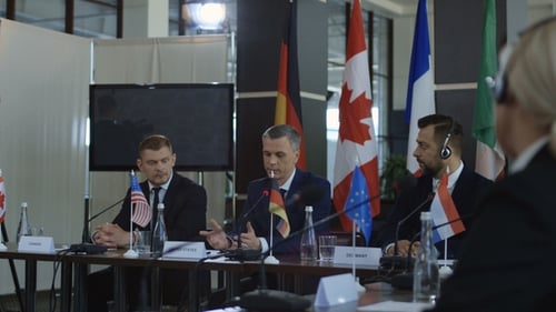 Men In Suits Shake Hands At Conference Table