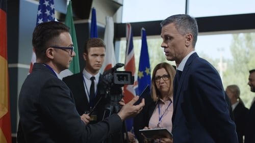 Political Interview With Flags Backdrop At Corporate Event