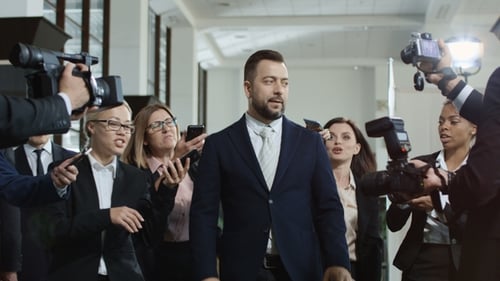 Man Addressing the Press, Surrounded by Reporters