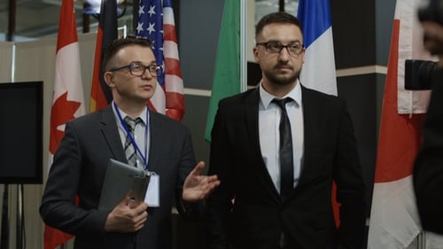 Men in Suits Giving a Press Conference
