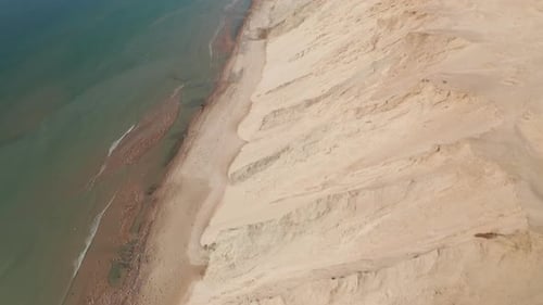 Gorgeous Aerial View of Top Dune Formation and Coastline With Calm Seawater