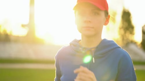 Woman Runs Through the Stadium at Sunset