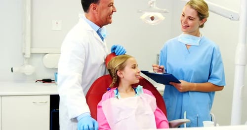 Dentist interacting with female dental assistant
