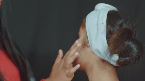 Close up of woman in cosmetics studio and professional make up artist preparing her for make up