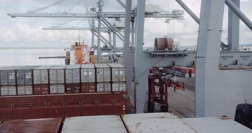 Containerhafen- und Turmkrane gegen klaren Himmel und flauschige Wolken