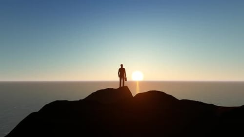 Businessman Silhouette on Mountain Peak at Sunset