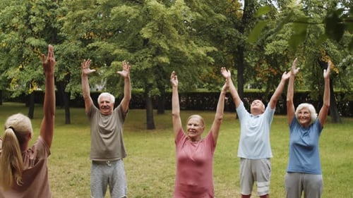Active Elderly People Having Group Fitness Class in Park
