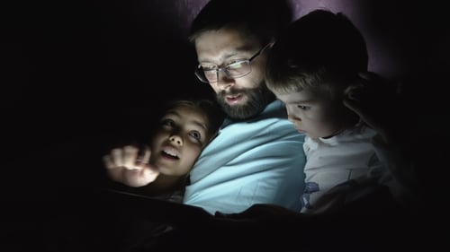 Father and Children Reading Tablet Computer at Night