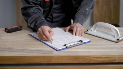 Builder Doing a Work Sketches on Paper.