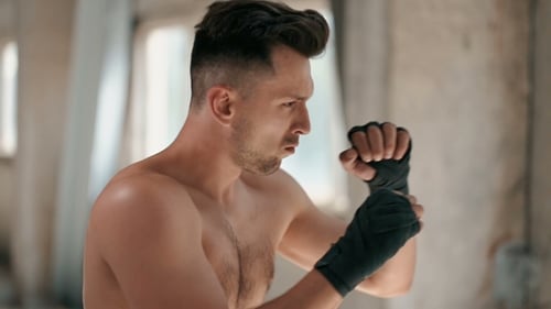 Shirtless Man Boxing and Punching in Training