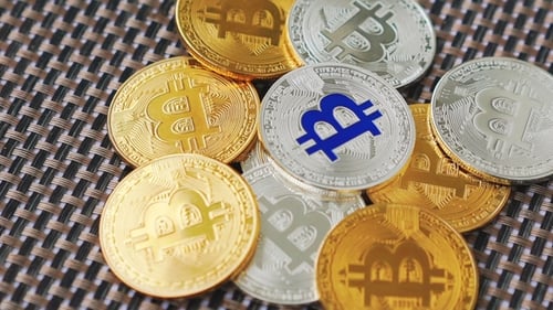 Goldene und silberne Bitcoins rotieren im Hintergrund
