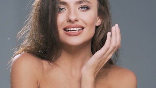 Gorgeous Woman Model with Curly Hair Posing at Isolated Gray Background in Studio