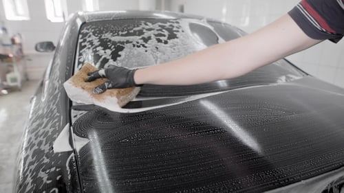 Hand Washes Car with Sponge and Soap