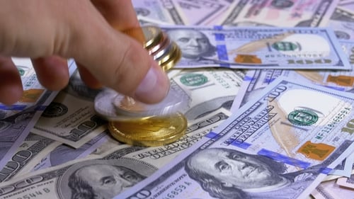 La main met les pièces cryptographiques de différentes devises sur une table avec des dollars américains