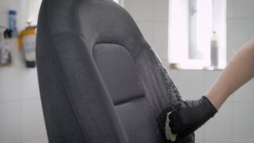 Detailer Cleaning Gray Fabric Car Seat