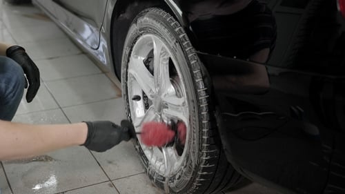 Man Washing Car Disks in Carwash.