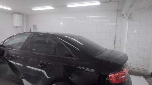 Car Being Pressure Washed in Cleaning Facility