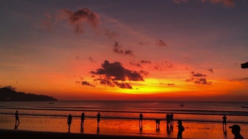 Beautiful Sunset on the Beach of the Jimbaran Village with Silhouettes of People. Bali, Indonesia