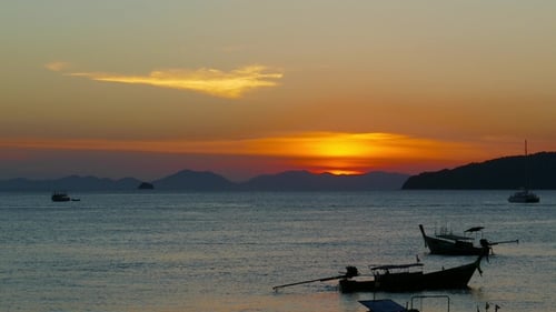 Long Tail Boats in the Sea at Sunset