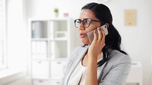 Businesswoman Calling on Smartphone at Office