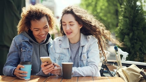 Women Friends Using Smartphone at Outdoor Cafe