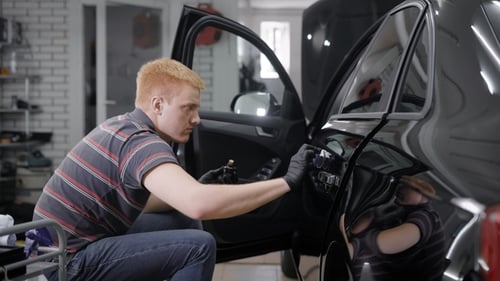 Man Applies Ceramic Coating to Car in Shop