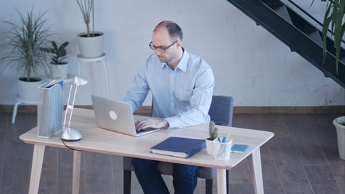 Handsome Businessman Working with Laptop in Office