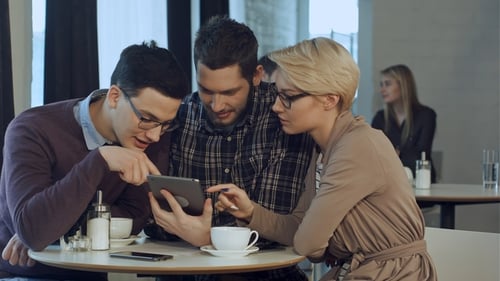 Creative Team Using Smartphone and Talking in Casual Office