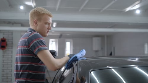 Man Cleaning a Car in Auto Detailing Shop