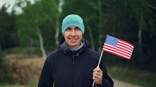 Portrait of Handsome Guy American Citizen Holding Flag of the United States