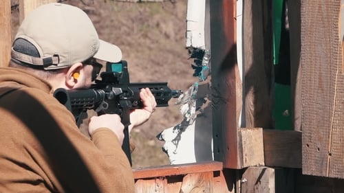 Images. Un homme qui tire tire sur une carabine dans un Killhouse d'entraînement