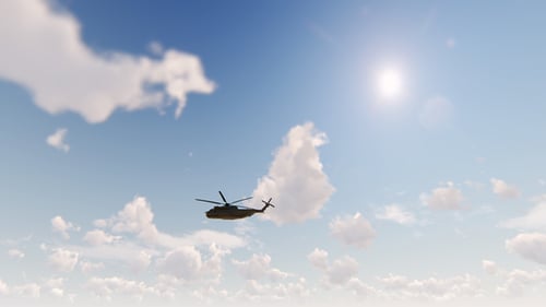 Military Helicopter Flying Across Sunny Blue Sky with Clouds