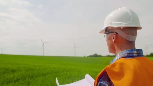 Engineer Writing On Clipboard While Doing Wind Turbine Inspection