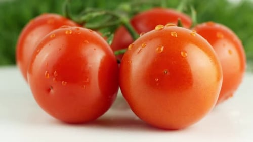Reife natürliche Tomaten aus nächster Nähe. Bio-Tomate, die sich auf grünem Hintergrund drehen. Makroaufnahme.