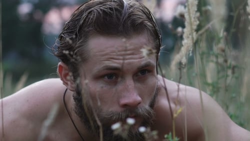 Homme barbu de peur regardant autour de lui dans l'herbe de la steppe