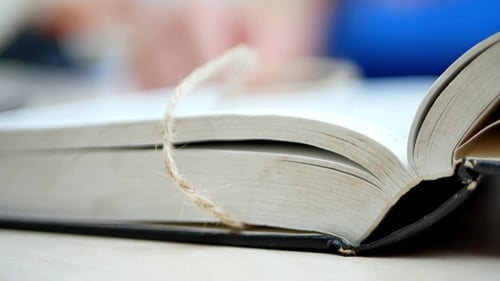 Woman's Hands Open The Book On The Table And Find Information