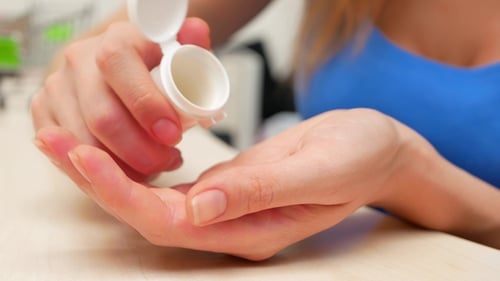 Woman Dispensing Pills from Prescription Bottle