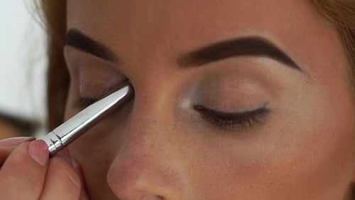 Woman Having Eye Makeup Applied in Close Up