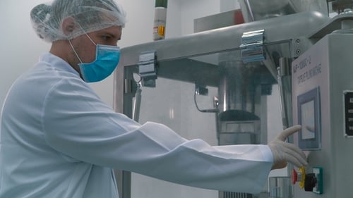 Laborant drückt Knöpfe an der Maschine im Labor