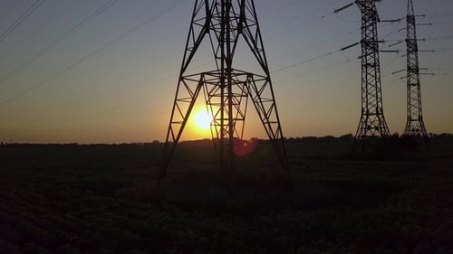 Torre de energía de alta tensión y puesta de sol