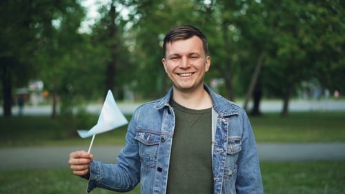 Smiling Man Waving Flag Outdoors