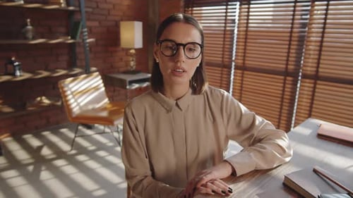 Woman Speaking at Desk in Bright Indoor Setting