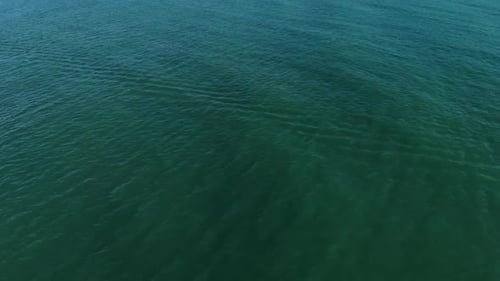 The Camera Flies Over the Sea Towards the Clear Horizon. The Camera's View Rises From the Sea