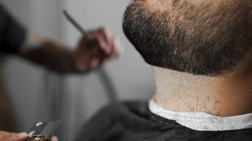 Tattoed Barber Shears the Customer's Beard By Using Trimmer at the Barber Shop, Man's Haircut
