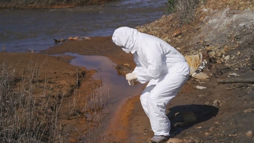 The Scientist in a Chemical Protective Suit Examines the Samples in the Contaminated Area. Biohazard