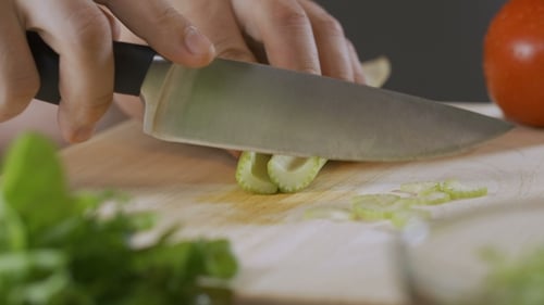 La main d'un chef expert coupe le céleri