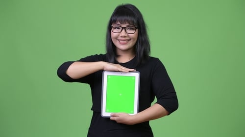 Woman Holding Tablet With Green Screen Smiling