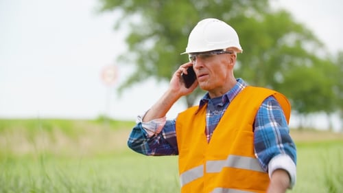 Engineer Analyzing Traffic Polution On Clipboard Amidst Crops At Farm
