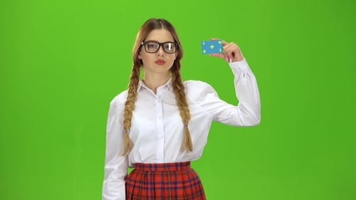 Schoolgirl in Glasses Shows a Finger Down . Green Screen